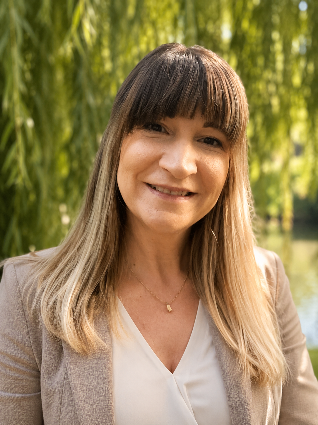 Portrait of Louise, a therapist with kind eyes, sitting in a calm naturally-lit therapy room